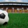 soccer ball on grass with stadium background